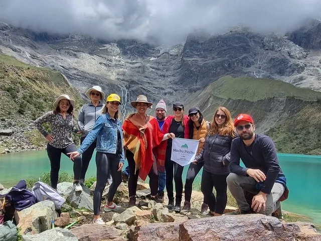 Gruppe von Touristen, die gemeinsam am wunderschönen Humantay-See posieren
